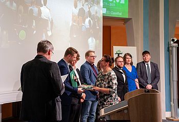 Urkunden werden an Absolventinnen und Absolventen übergeben. 