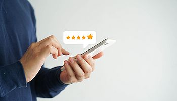 Finger auf einem Handy mit Sternen darüber