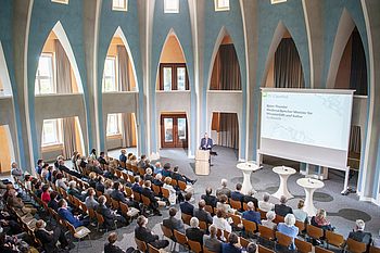 Personen in einem Saal bei einer Präsentation