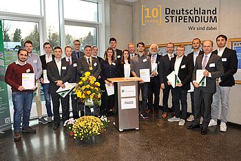 Menschen stehen neben einem kleinen Stand und Blumen 